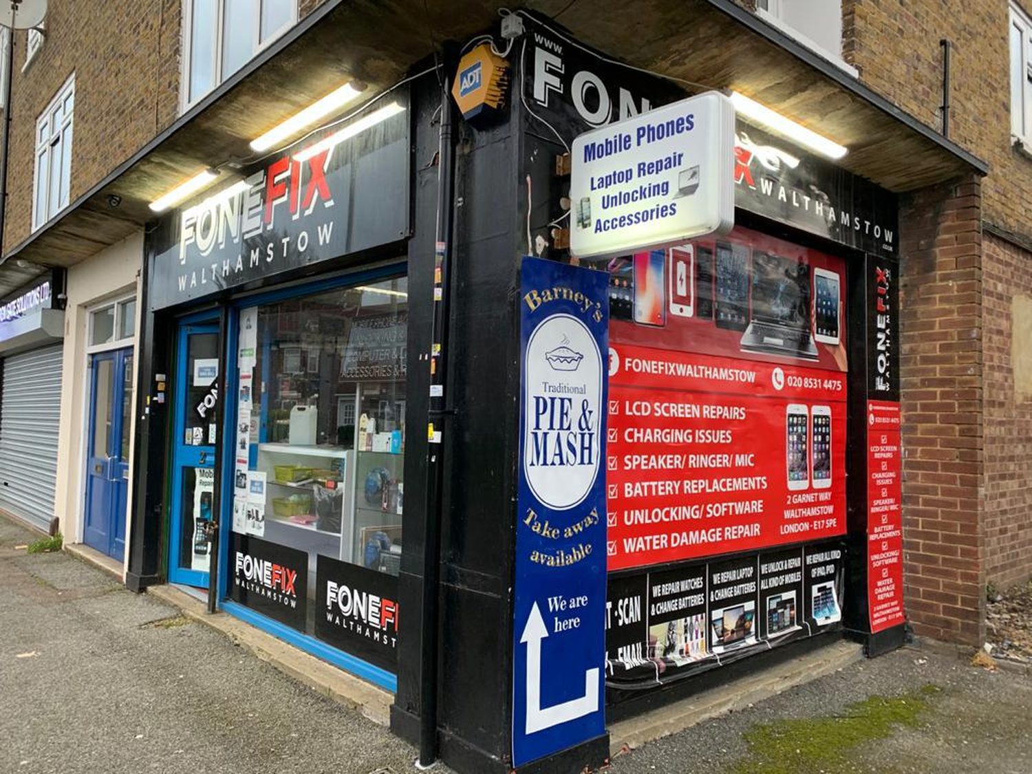 The FoneFix Walthamstow shopfront on the corner of Garnett Way, E17: black fascia with the FONEFIX sign and a red board listing screen repairs, charging, battery and water-damage services.